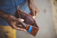 Overhead Shot Of A Male Holding His Empty Wallet With A Blurred Background