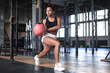 © ty - Fit and muscular woman exercising with medicine ball at gym.