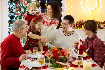 Wall Mural - Family with kids having Christmas dinner at tree