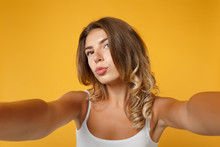 Close Up Young Woman Girl In Light Clothes Posing Isolated On Yellow Orange Background. People Lifestyle Concept. Mock Up Copy Space. Doing Selfie Shot On Mobile Phone Blowing Lips, Showing Duck Face.