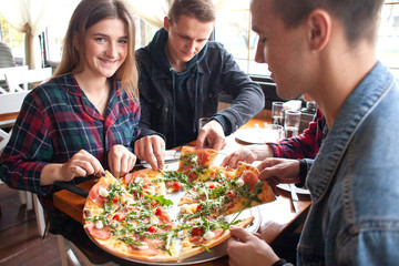 friends of classmates eat pizza in a pizzeria, students at lunch eat fast food