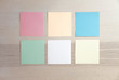 blank empty pastel colors sticky notes on clean wood background, from top view with copy space