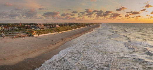 Wall Mural - wide shot of the ocean and the beach under the colorful sky captured in domburg, netherlands