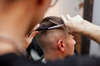 © Богдан Маліцький - handsome guy get a haircut at the hairdresser, Kazakh hairdresser cuts manually with scissors and a comb, short haircut close-up