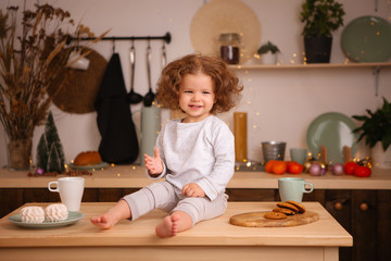 baby girl in pajamas in Christmas kitchen