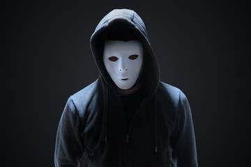 Wall Mural - masked anonymous hacker on black background.