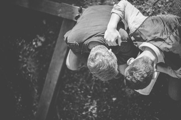 Overhead shot of two male reading the bible in black and white