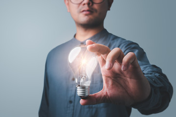 Leinwandbilder - businessman holding light bulb. idea concept with innovation and inspiration Creativity and innovative are keys to success.Concept of new idea and innovation with light bulbs.