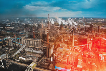 Wall Mural - Aerial view of Factory or Plant Industrial Area with many pipes or chimneys with smoke in red sunlight flare. Heavy industry, landscape from drone.