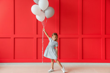 Wall Mural - Little girl with balloons near color wall