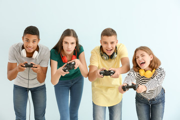Poster - Teenagers playing video games against light background