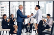 © Art_Photo - Image two business partners in elegant suit successful handshake together standing in front of group of casual business clapping hands in modern office.Partnership approval and thanks gesture concept