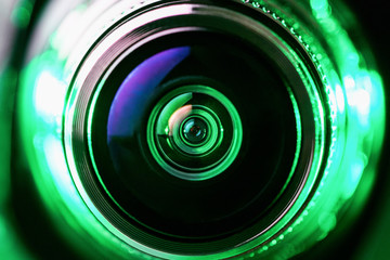 Wall Mural - The camera lens and green backlighting. Green camera Lens close Up. Gorizontal photo