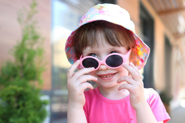 Happy smiling girl child in sunglasses outdoor portrait