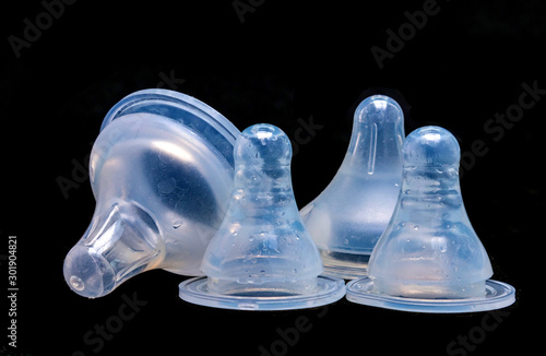 Fotomural Small and large baby teat with black background, isolated black background