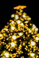 Wall Mural - Look up view blurred and bokeh of Christmas lighting on Christmas tree and black background.