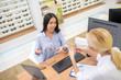 © zinkevych - Blonde eye specialist talking to client and recommending glasses