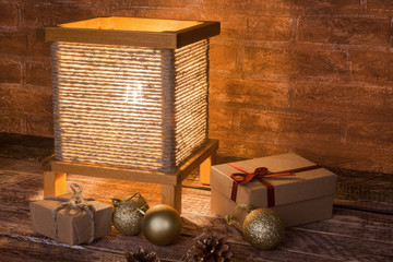 vintage table lamp, gift boxes and colored christmas balls on wooden background. time for holiday.