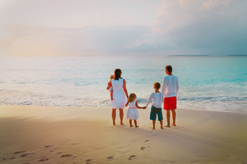 Wall Mural - happy family with kids looking at sunset on beach