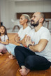 © alfa27 - Beautiful family meditating at home , sitting on floor. Family, sport, yoga concept. White colors