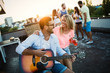 © NDABCREATIVITY - Group of happy friends having party on rooftop