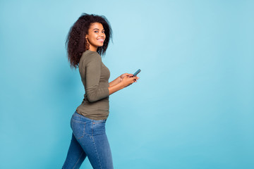 Poster - Profile side photo of positive cheerful girl use her smartphone have fun on weekends enjoy read blog feednews in social network wear green sweater denim jeans isolated blue color background