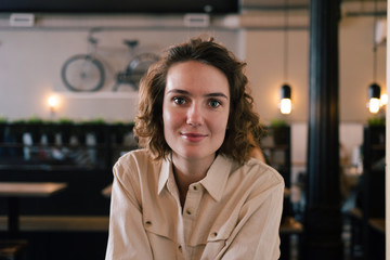 young smiling confident female close up portrait in cafe