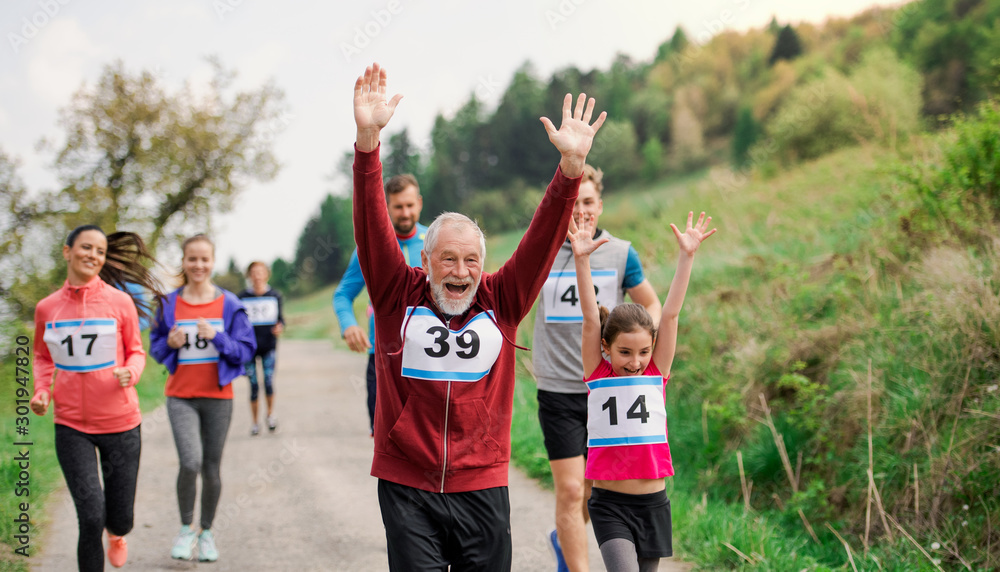 Large group of multi generation people running a race competition in ...