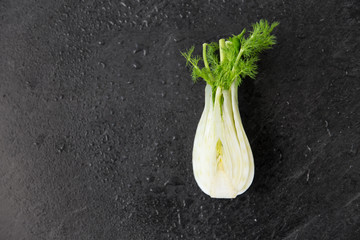 vegetable, food and culinary concept - fennel on slate stone background