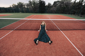 Wall Mural - Luxury glamour fashion woman on tennis court holding racket and posing like model