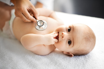 medicine, healthcare and pediatrics concept - close up of female doctor with stethoscope listening t