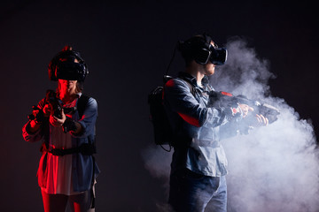 Studio photo of gamers standing in smoke. Ultra violet, virtual reality. Black background