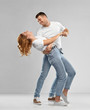 © Syda Productions - relationships and people concept - portrait of happy couple in white t-shirts dancing over grey background