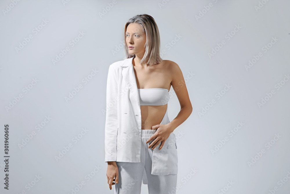 Beautiful woman with creative makeup on grey background