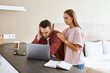 © alfa27 - Sad dissatisfied man with thick beard dressed in red shirt, puts head on hand, reads unpleasant message, stares at laptop computer screen, portrait, indoor shot