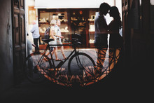 Silhouette Of A Love Couple. Man And Woman Gently Hug. Walk With A Bike
