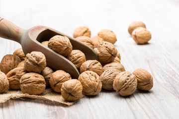 Wall Mural - bunch of walnuts with wooden scoop on table