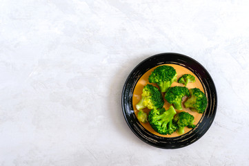 Wall Mural - Boiled broccoli on a plate on a light background. Healthy eating concept. Sports diet. Proper nutrition. Healthy lifestyle. Free space. Top view.