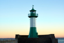 Green Striped Lighthouse With Clear Gradient Blue Sky At Sunset