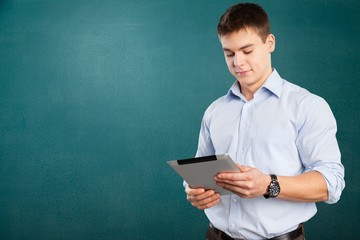 Canvas Print - Young male teacher   standing with book