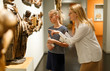 © JackF - Young woman in glasses with daughter using guide book at exhibition in museum