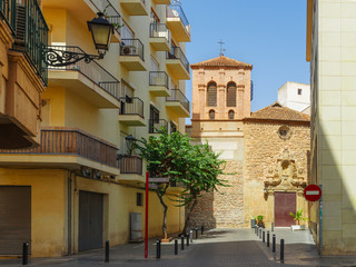 Empty narrow street in old european city rests against church wall