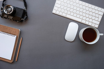 Work office desk with keyboard, mouse, coffee, notepad, pencil, glasses and photo camera