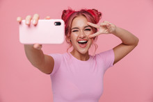 Portrait Of Young Woman Showing Peace Sign And Taking Selfie Photo