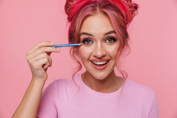 Sticker - Portrait of caucasian woman laughing and applying makeup with eye pencil