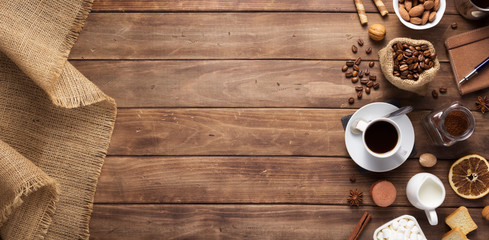 Poster - cup of coffee and beans on wooden background