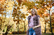 © RomanR - Fashion woman. Smiling girl in fur coat posin in autumn park with trees and ivy