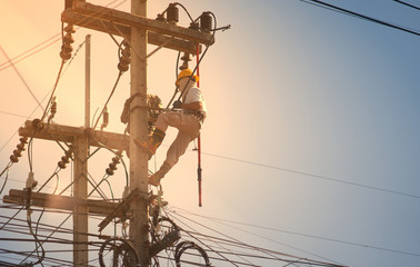 technician work on high voltage electic pole with sunflare