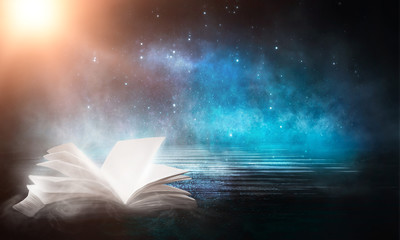 Wall Mural - an open book on a wooden table under the night sky against a dark forest. magical radiance. night sc