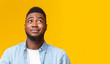 Cynical guy looking upwards at copy space on yellow background